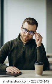 Young business man working on computer aqnd drinking coffee at the office - Shutterstock ID 2255724145