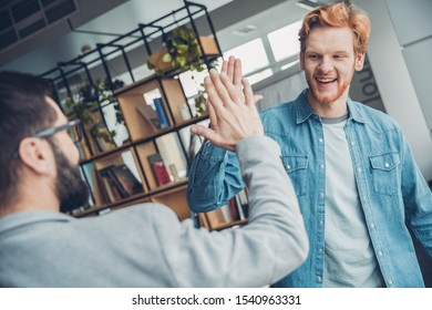 Young Business Men Working Together At Office Standing Giving High Five Bearded Guy Back View Close-up Smiling Cheerful