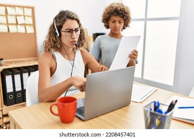 Young Business Mother Working At The Office With Kid Pointing With Finger To The Camera And To You, Confident Gesture Looking Serious 