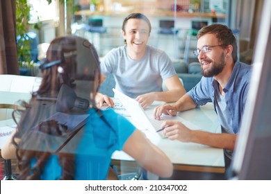 Young business partners discussing ideas or project at meeting in office - Shutterstock ID 210347002