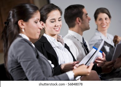 Young Business People Or College Students Sitting In Row Reading Report In Presentation