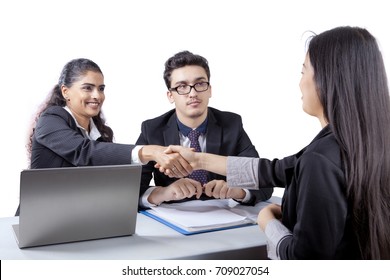 Young business people giving a congrats sign by shaking hands on a new employee, isolated on white background