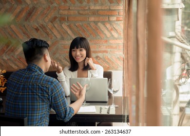 Young Business People Having Meeting In A Cafe