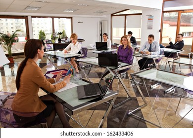 Young Business People Meeting With Their Leader. Modern Office Classroom With Students Listening To Their Trainer