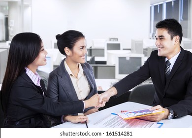 Young business people shaking hands, finishing up a meeting