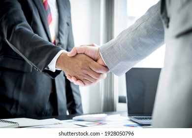 Young Business People Shaking Hands In The Office. Finishing Successful Meeting. Three Persons. Wide Screen Panoramic