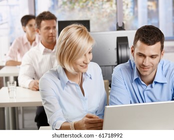 Young Business People Sitting At Desk, Using Computer At Business Training, Smiling.?