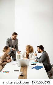 Young Business People Sitting At Meeting Table In Conference Room Discussing Work And Planning Strategy