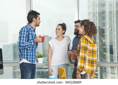 Young Business People Talking While Coffee Break In Their Office