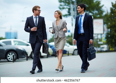 Young Business People Walking Together Along The Street