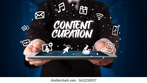 Young business person working on tablet and shows the inscription: CONTENT CURATION - Shutterstock ID 1612210927