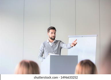 Young Business Speaker Gesturing While Standing In Conference Room