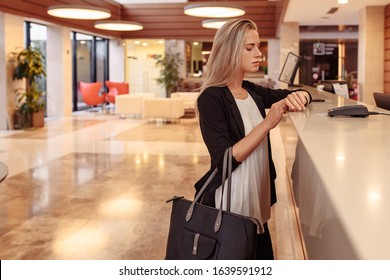 Young business stylish girl dissatisfied with service in Bank. Poor customer support. A woman is late for a corporate meeting, demands a complaint book for an bad review of hotel and its employees