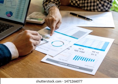 Young Business Team In Casual Style Have Small Meeting In The Office Talk About  Analyses Chart Graph Marketing Plan With Computer Laptop Calculator.