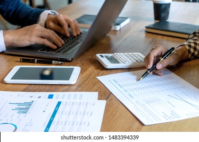 Young Business Team In Casual Style Have Small Meeting In The Office Talk About  Analyses Chart Graph Marketing Plan With Computer Laptop Calculator.