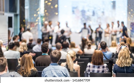 Young business team receiving award prize at best business project competition event. Business and entrepreneurship award ceremony theme. Focus on unrecognizable people in audience. - Shutterstock ID 1416847709