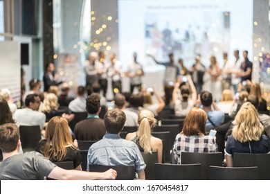 Young business team receiving award prize at best business project competition event. Business and entrepreneurship award ceremony theme. Focus on unrecognizable people in audience. - Shutterstock ID 1670454817
