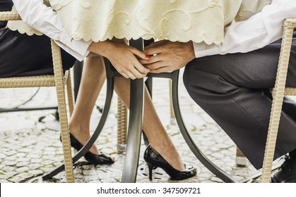 Young Business, Well Dressed Couple Holding Hands Under The Table While Using Laptops