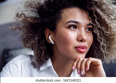 Young business woman with airpods looks away