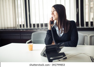 Young Business Woman Calling And Communicating With Partners.Customer Service Representative On The Phone.Cheerful Secretary Answering Phone In Her Office And Drinking Coffee