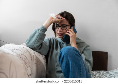 Young business woman calling on smartphone to her work to say that she is sick and she cant go to work. Frustrated female feeling ill and have high body temperature talking with her boyfriend.