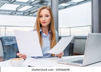 Young Business Woman Comparing Documents At Office