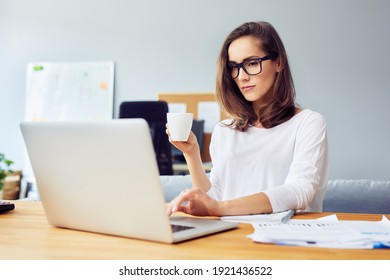 Young Business Woman Drinking Coffee Using Laptop Working From Home Office