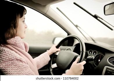 Young Business Woman Driving Car In Rain (focus On Face)