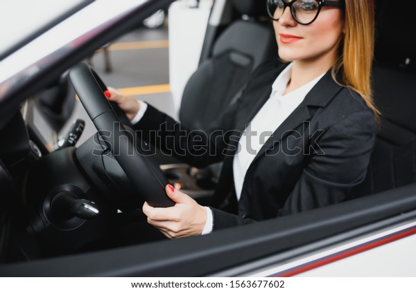 Young business woman\
driving in her car to work. Successful business concept. business\
woman driving
