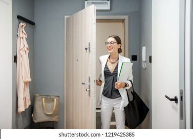 Young Business Woman Entering The Apartment Returning From The Work To Home