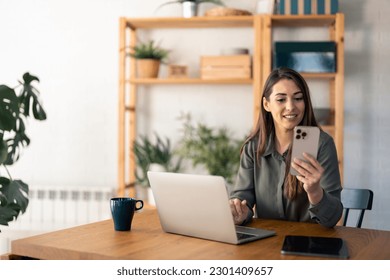 Young business woman entrepreneur using laptop and mobile phone at the working space. - Powered by Shutterstock
