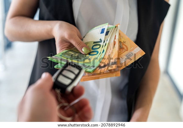a young
business woman is given car keys and she is euros for a car. The
concept of buying a car. Business
concept