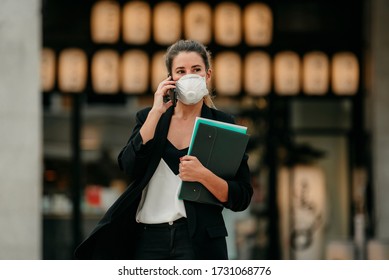 Young Business Woman Goes To Work Talking On The Phone With Medical Mask