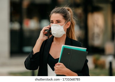 Young Business Woman Goes To Work Talking On The Phone With Medical Mask