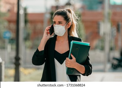 Young Business Woman Goes To Work Talking On The Phone With Medical Mask