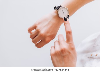 A young business woman is late on time, in a hurry she checks the deadline on her classic watch - Shutterstock ID 407554348