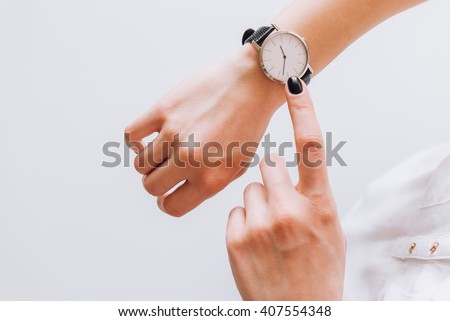 A young business woman is late on time, in a hurry she checks the deadline on her classic watch