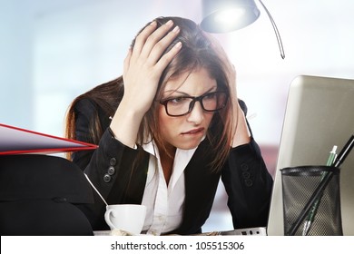 A young business woman is looking stressed as she works at her computer
