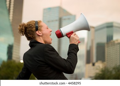 Young business woman making herself heard with a megaphone.