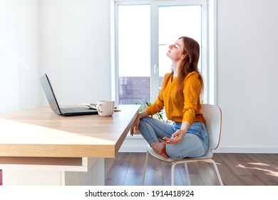 Young Business Woman Is Meditating After Work The Internet Using A Computer. Female Girl Listens To Calm Music Near The Laptop. Home Comfort Zone And Mental Health Concept.