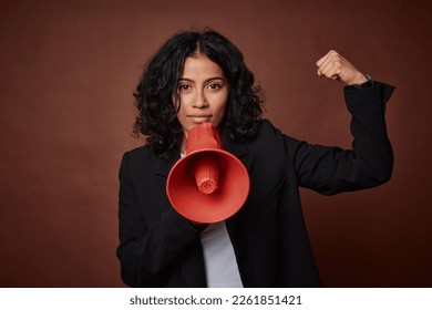 A young business woman passionately advocates for her rights with a megaphone. - Powered by Shutterstock