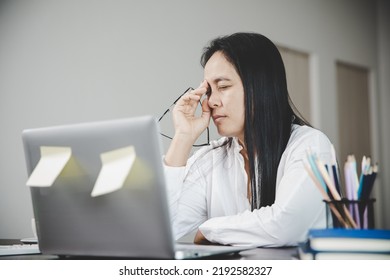 Young Business Woman Person Sleepy And Has Frustration Eye Problems With Cephalalgia Disease From Using Laptop Computer On Her Office Desk. Stressed Female Employee Tired And Exhausted From Overwork.