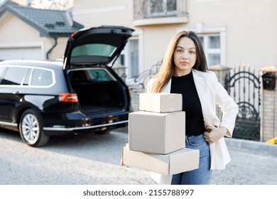 Young Business Woman Picking Up Parcels From A Car Trunk, Coming Home By Car.