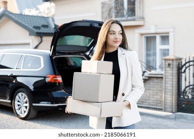 Young Business Woman Picking Up Parcels From A Car Trunk, Coming Home By Car.