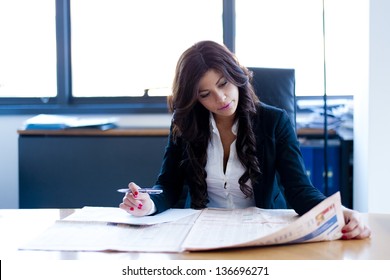 Young Business Woman Reading Sitting At The Desk On Office Background