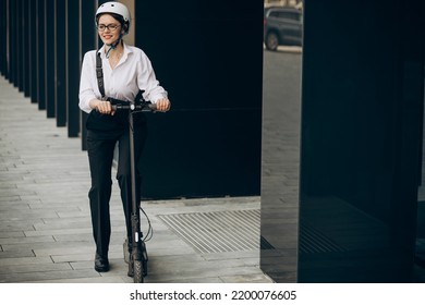 Young Business Woman Riding Electro Scooter By Ofice Center