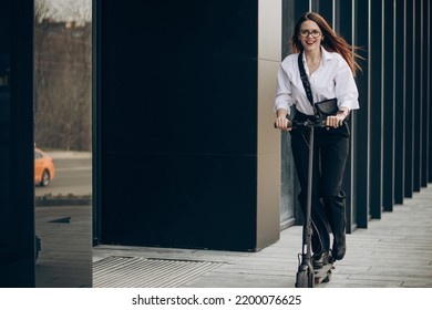 Young Business Woman Riding Electro Scooter By Ofice Center