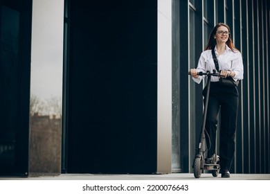 Young Business Woman Riding Electro Scooter By Ofice Center