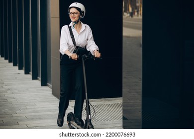 Young Business Woman Riding Electro Scooter By Ofice Center