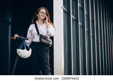 Young Business Woman Riding Scooter And Using Phone